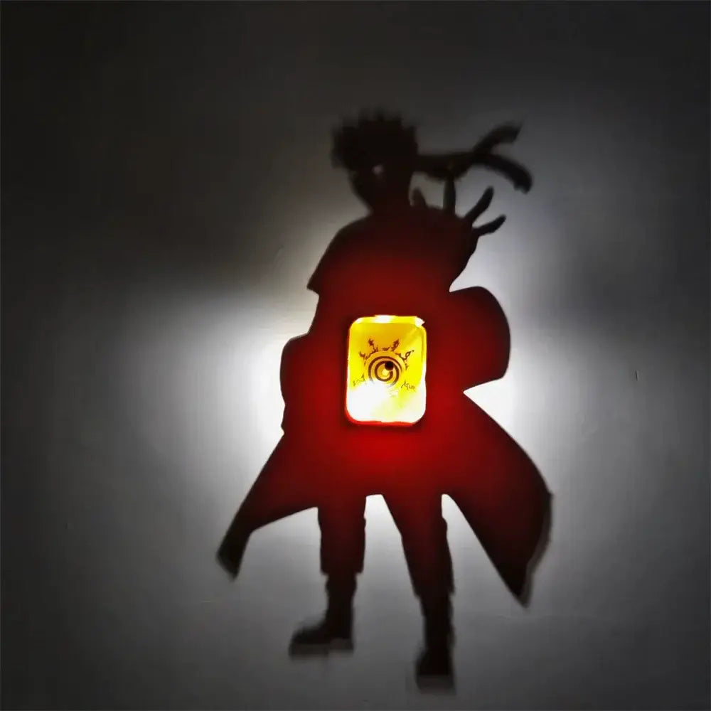 Red illuminated silhouette of naruto uzumaki with glowing yellow emblem on chest in one piece luffy shadow light projector