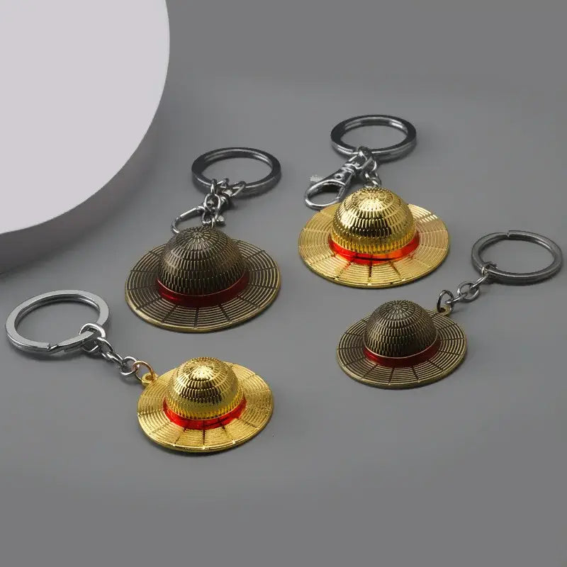 One piece monkey d luffy hat keychain featuring golden straw hat with red bands and metallic detailing pendant keyring
