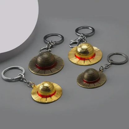 One piece monkey d luffy hat keychain featuring golden straw hat with red bands and metallic detailing pendant keyring