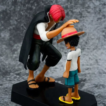 One piece monkey d luffy pvc statue 18cm showing a red-haired figure in black cloak kneeling beside a boy in straw hat
