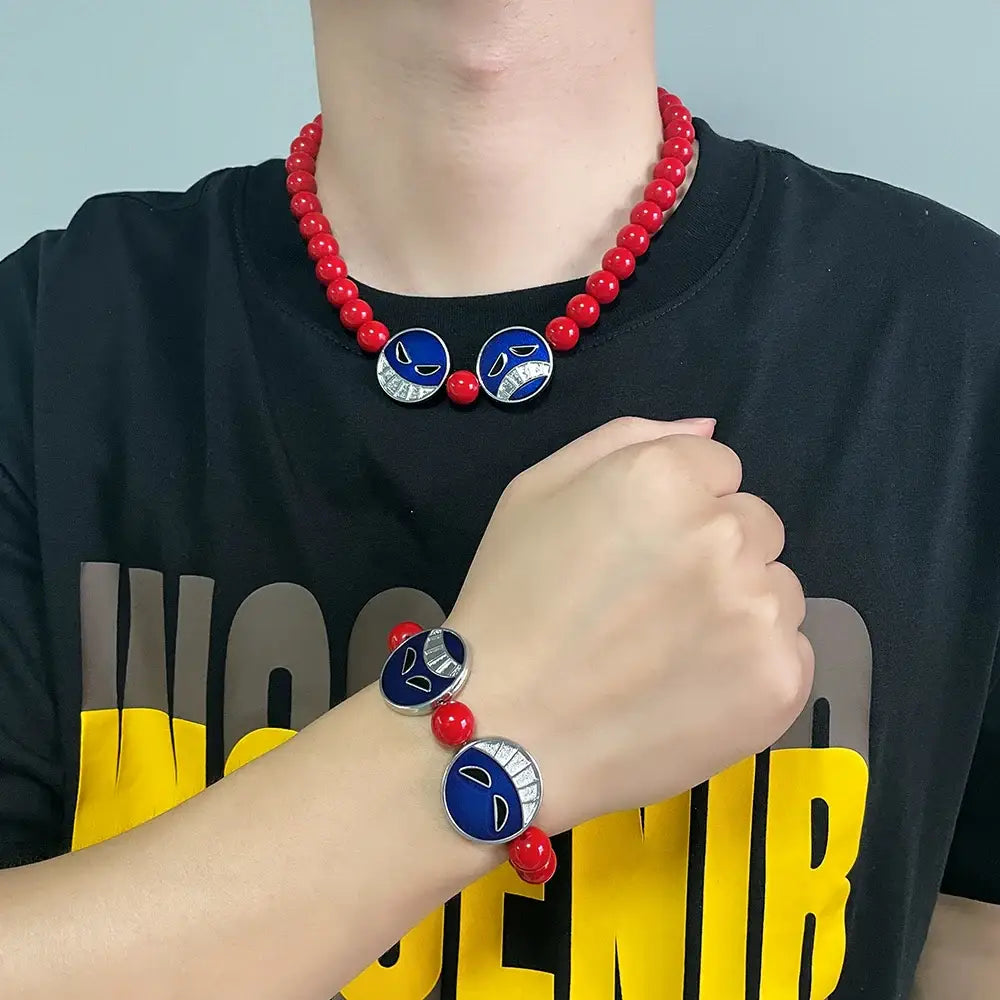 Red beads bracelet and matching necklace with blue circular charms featuring silver-trimmed smiling faces