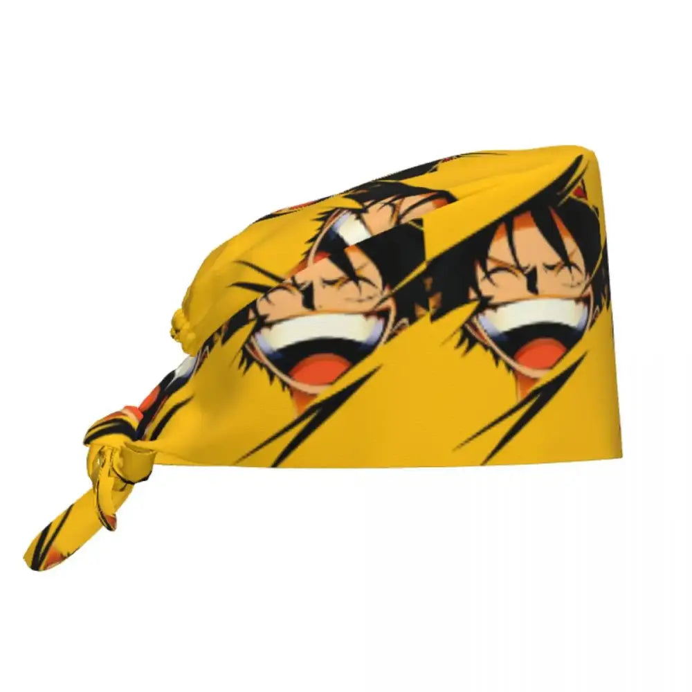 Bright yellow one piece scrub cap with bold cartoon print of two smiling anime characters and black hair