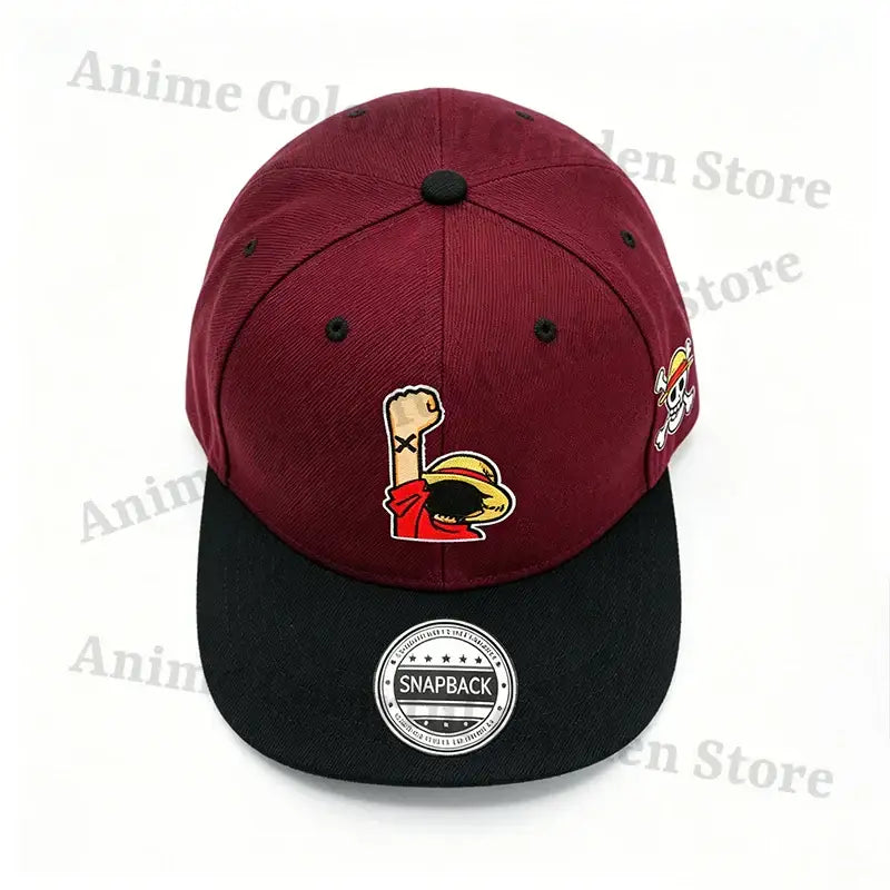 Maroon and black cotton baseball cap with embroidered luffy fist logo front and skull emblem side one piece straw hat design