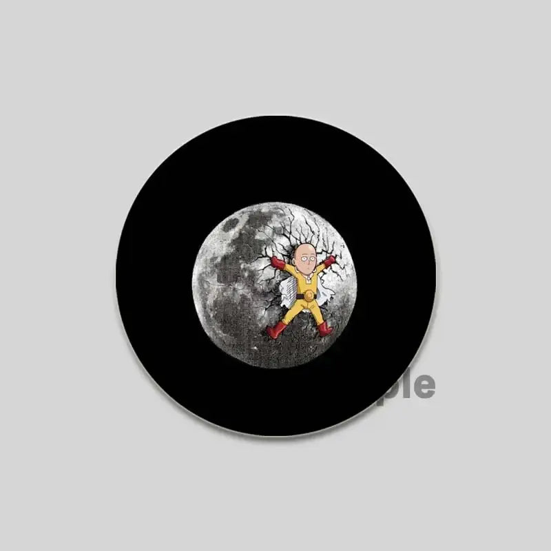 Black circular one punch man saitama brooch pin featuring saitama in yellow suit standing on cracked moon design