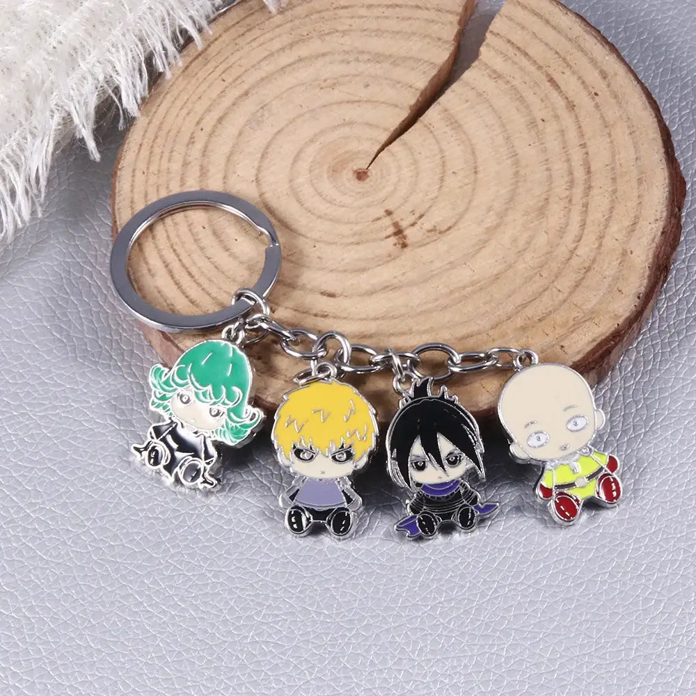 A silver punch man saitama metal keychain with four colorful chibi-style enamel charms featuring anime characters