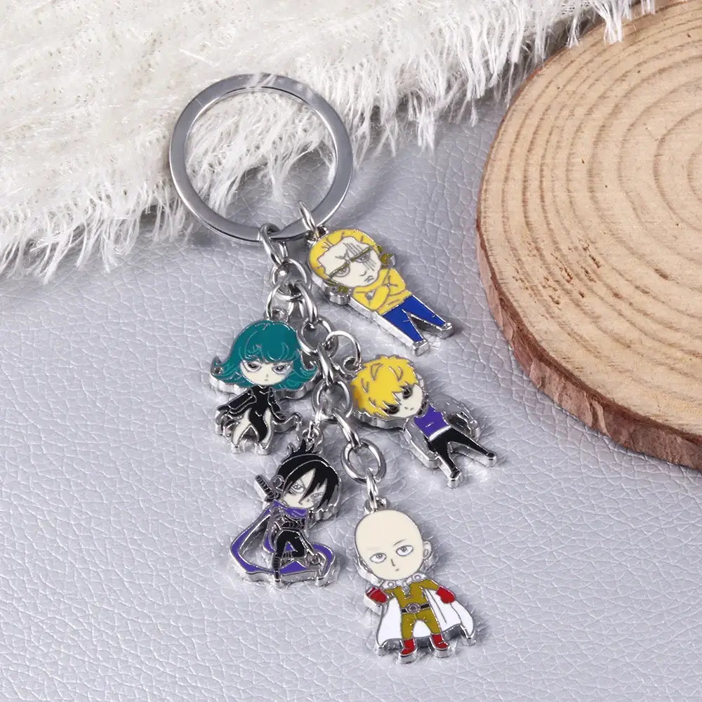 A silver-toned man saitama metal keychain with five colorful enamel one punch man saitama character charms