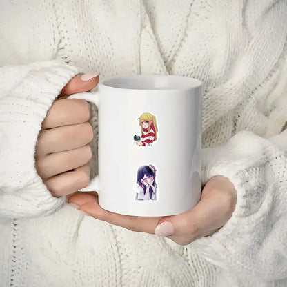 White ceramic mug with two oshi no ko ai hoshino stickers from 50pcs aesthetic diy scrapbook set