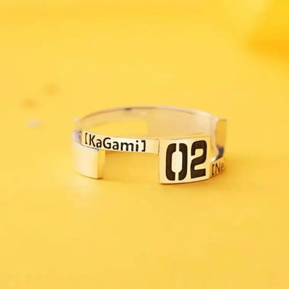A sleek sterling silver ring featuring a rectangular plate engraved with bold black 02 and kagamine rin text