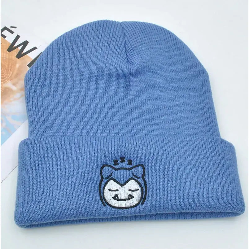 Light blue knitted hood hat featuring an embroidered sleepy snorlax face in plush knit style