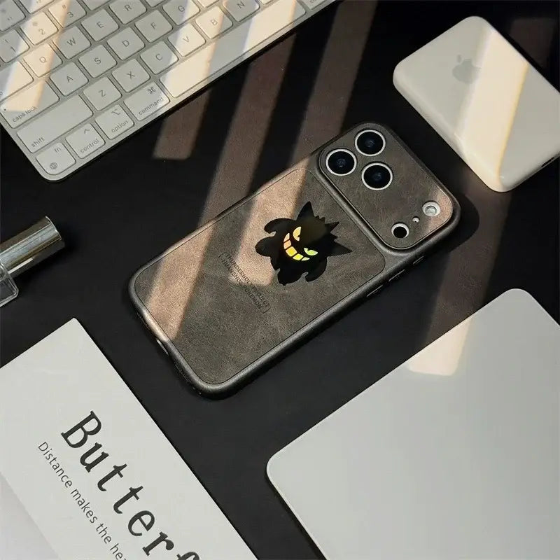 Dark gray pokemon gengar phone case with glowing yellow eyes featuring laser leather texture on the back side