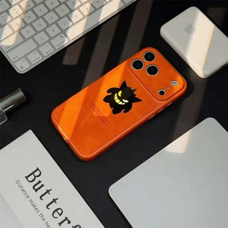 Orange phone case featuring black and yellow pokemon gengar design with laser leather texture on the back side