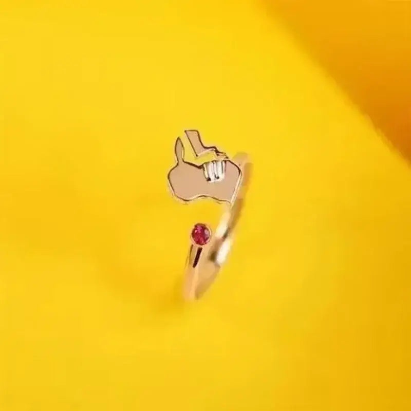 Rose gold 925 silver couple ring featuring a stylized hand gesture with an embedded red gemstone inspired by pokemon