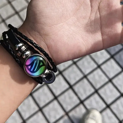 Pokemon mega stone keychain featuring a black leather rope braided bracelet with an iridescent charm and silver accents