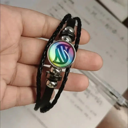 Black braided leather bracelet with circular rainbow emblem and silver beads on black leather rope keychain