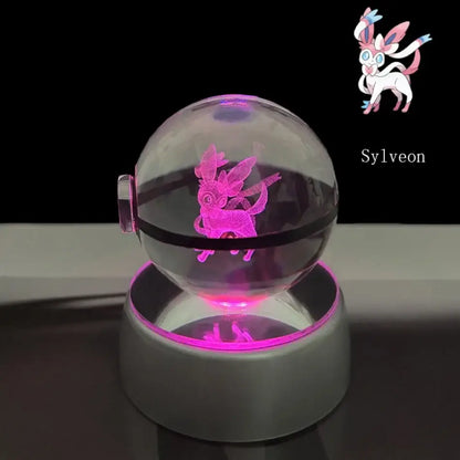 A glowing pink sylveon hologram inside a transparent crystal ball led lamp with a white base for pokemon night light