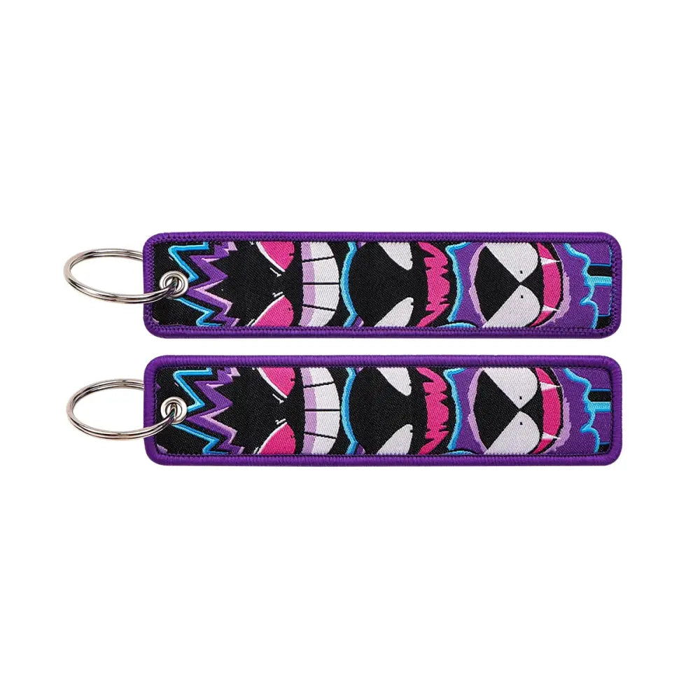 Purple embroidered pokemon pikachu keychain with vibrant black and white faces accented in pink and blue on jet tag accessory