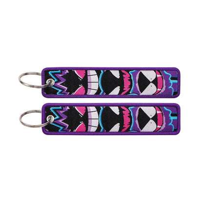 Purple embroidered pokemon pikachu keychain with vibrant black and white faces accented in pink and blue on jet tag accessory