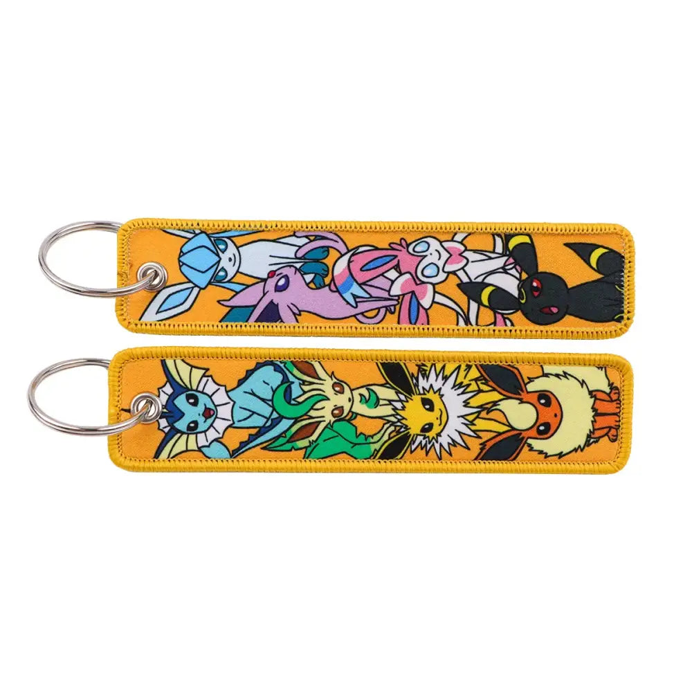 Two rectangular orange embroidered Pokemon Pikachu keychains featuring colorful characters for jet tag accessory