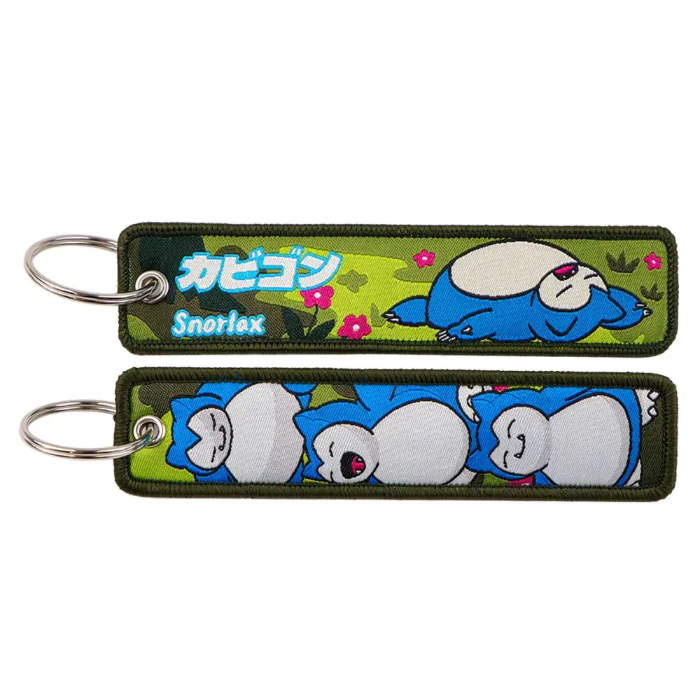 Blue and white snorlax embroidered keychain with green background and pink flowers for pokemon pikachu jet tag accessory
