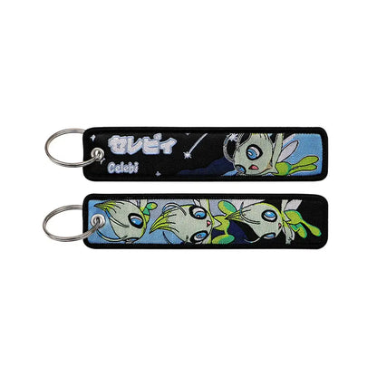 Black embroidered Pokemon Pikachu keychain featuring a green and white celebi with blue eyes on a starry night background