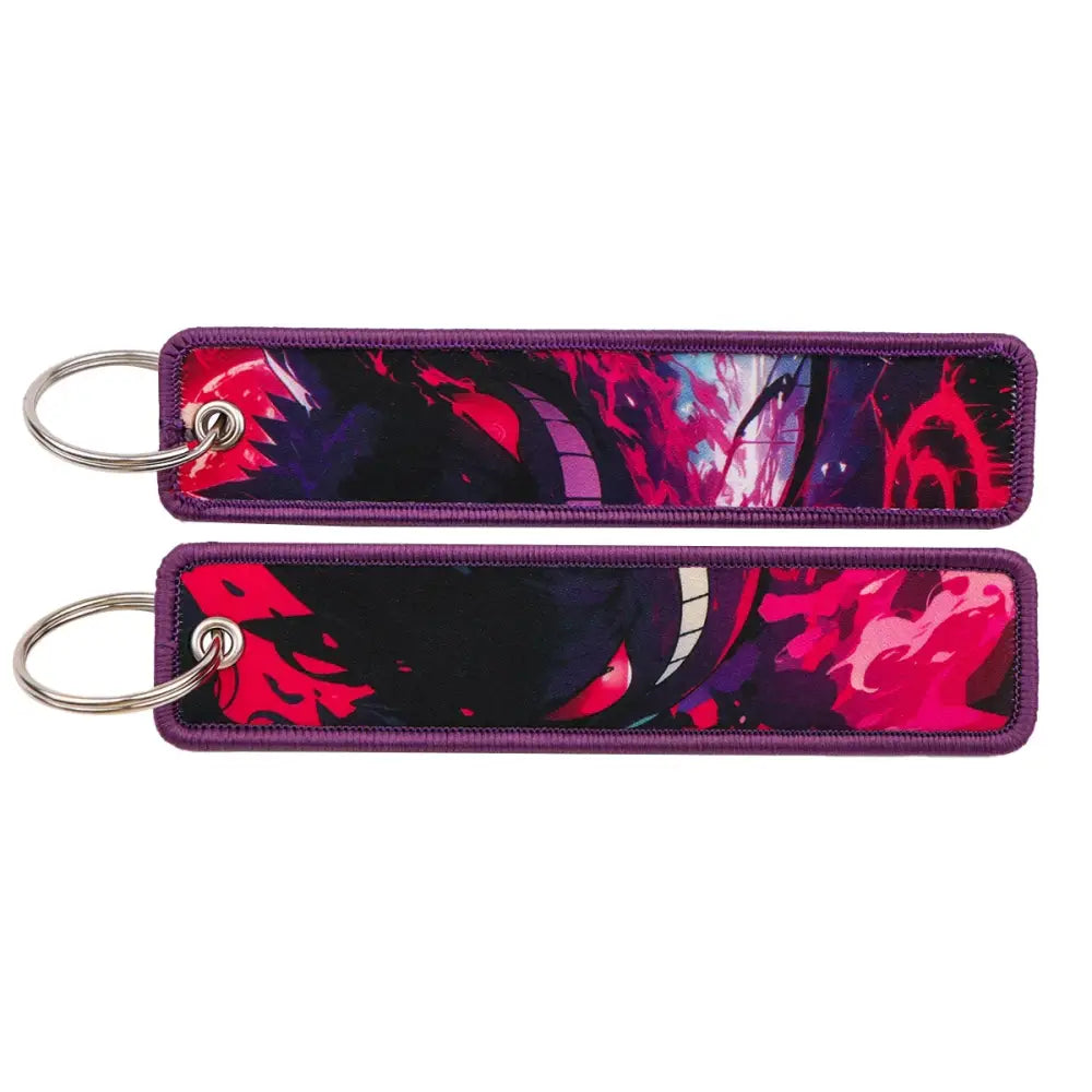 Two rectangular pokemon pikachu embroidered keychains with vibrant red black and purple anime-style fabric artwork