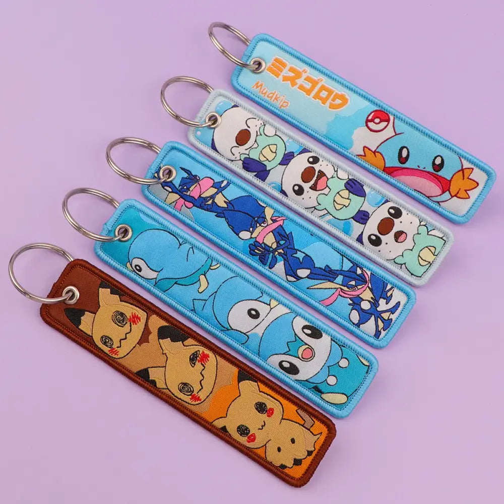 Blue and brown embroidered pokemon pikachu keychains featuring colorful characters as jet tag accessories