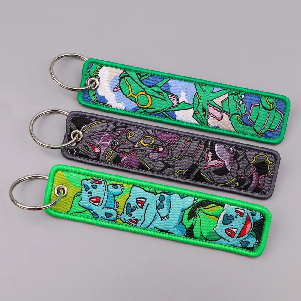 Three embroidered pokemon keychains with colorful fabric patches and metallic rings for jet tag accessories