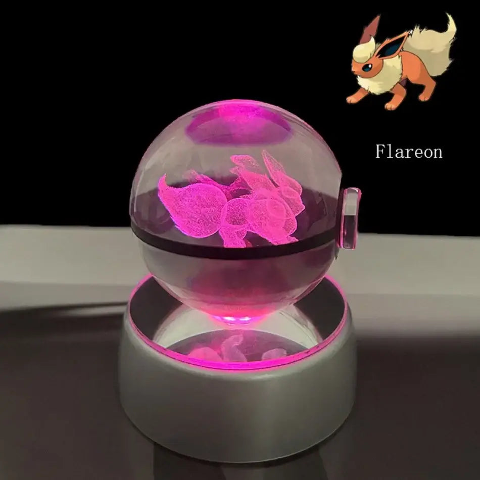 A glowing pink flareon figurine inside a transparent crystal ball pokeball led night light with a silver base
