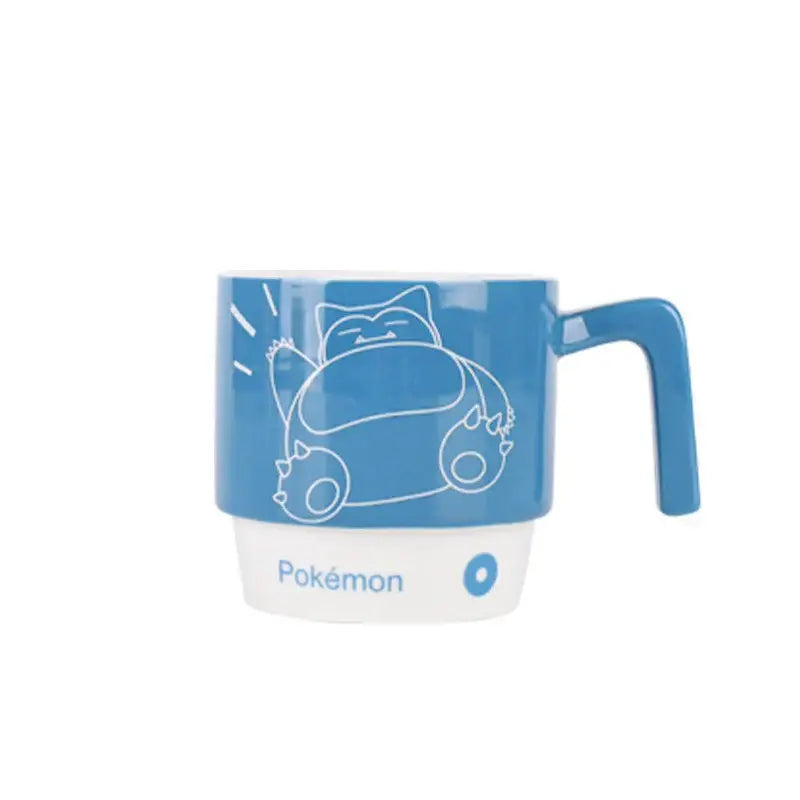 Blue ceramic mug featuring a white line drawing of snorlax with pokémon branding at the base in kawaii style