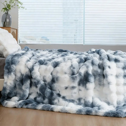 A plush faux rabbit chunky knit throw blanket in white and gray gradient with soft faux fur texture for cozy warmth