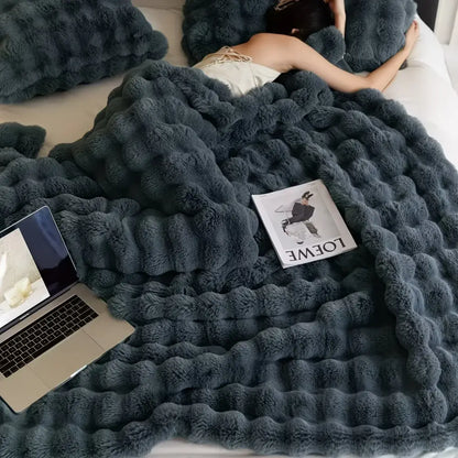A plush dark gray rabbit blanket made of soft faux rabbit fur with a thick, cozy, warm, and fluffy texture