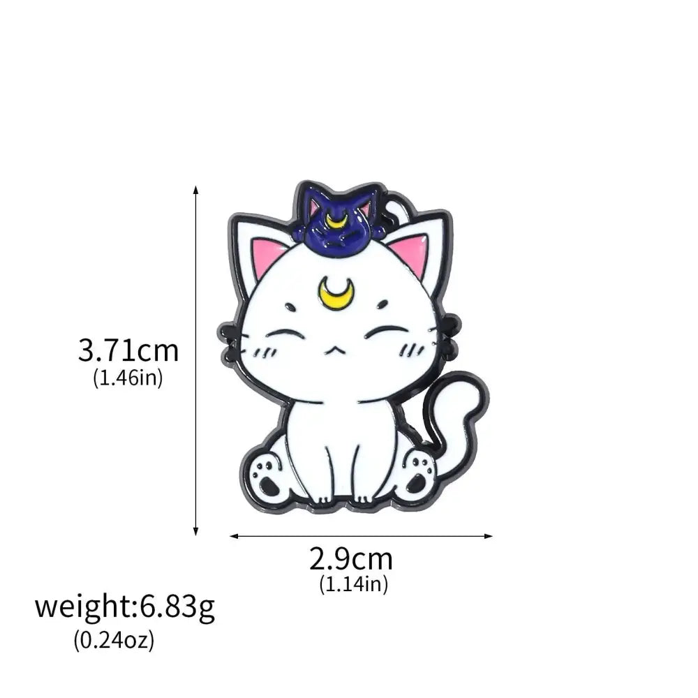 White enamel brooch pin of a cute cat with pink ears and a blue crescent moon hat from usagi enamel keychain collection