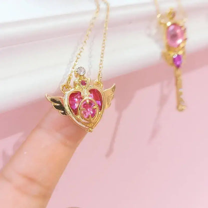 Gold heart-shaped pendant with wings and pink gemstones from sailor moon tsukino necklace set with clear crystal detail