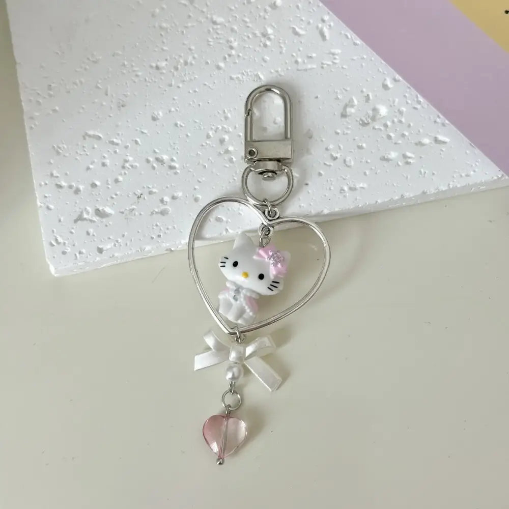 Silver heart-shaped acrylic phone chain keychain with white hello kitty figurine and pink accents by sanrio