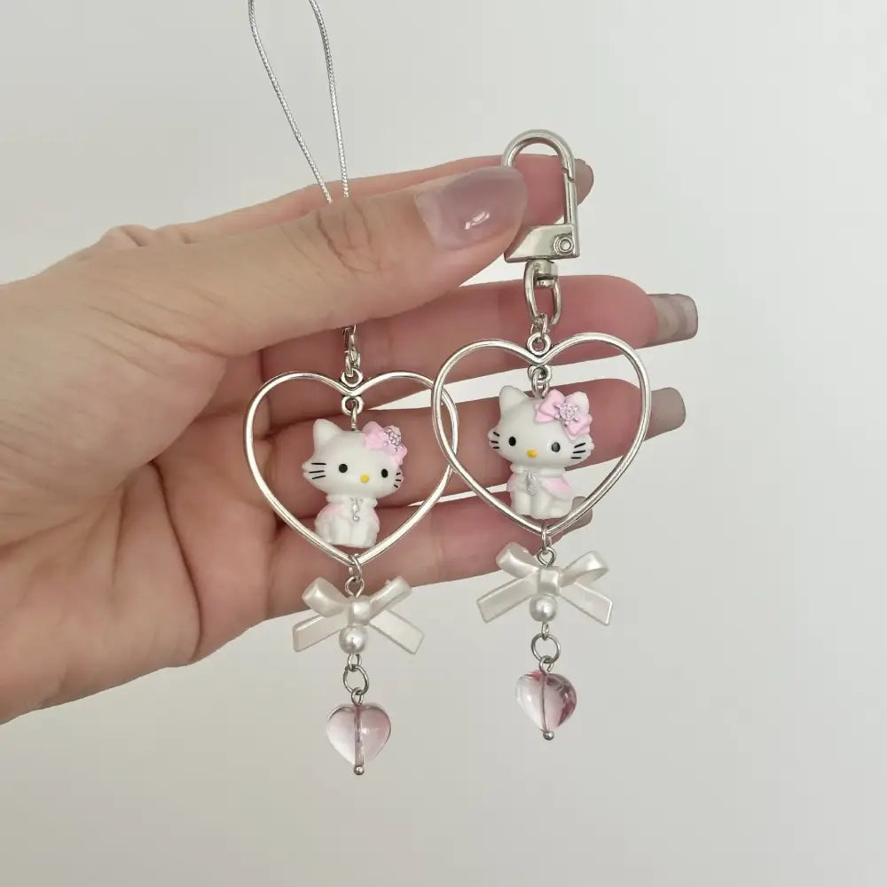White hello kitty charm with pink bow in heart-shaped metal frame on silver carabiner acrylic phone chain keychain