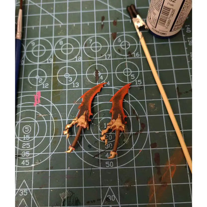 Two orange and brown intricately painted fantasy swords with serrated blades from solo leveling sung jin-woo action figure