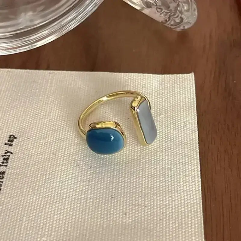 Gold-toned soul eater death the kid skull ring with vibrant blue oval and pale gray rectangular stones in metal bezels