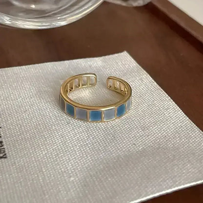 Gold-toned adjustable metal ring with blue and white enamel inlays featuring soul eater kid skull design