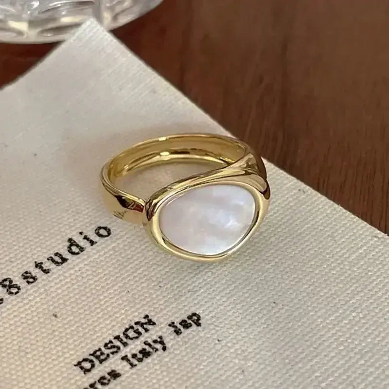Gold-toned soul eater death the kid skull ring with smooth oval mother-of-pearl stone and twisted metal band design