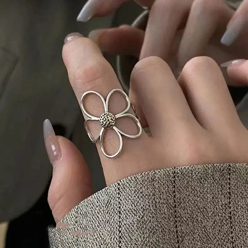 Silver soul eater kid skull ring with delicate open petal design and textured center adjustable metal band