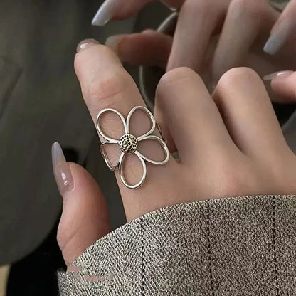 Silver soul eater kid skull ring with delicate open petal design and textured center adjustable metal band