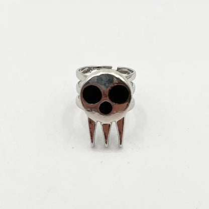 Silver soul eater kid skull ring with black inlaid eye and mouth holes and three pointed teeth adjustable metal