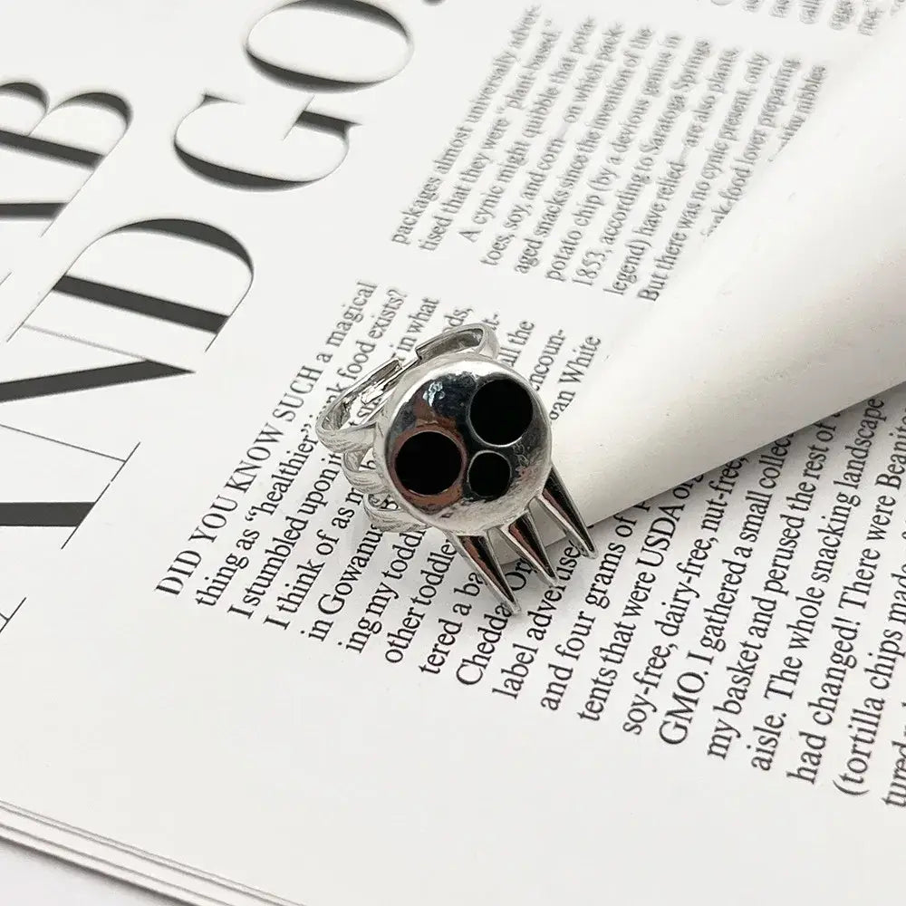 Silver soul eater kid skull ring with black inlaid eyes and sharp metallic spikes adjustable metal band