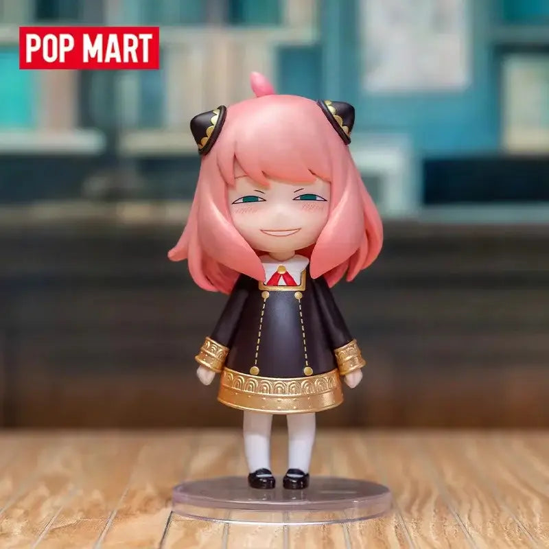 Pink-haired spy x family anya blind box figure in black and gold dress standing on clear base desktop collectible