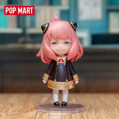 Spy x family anya blind box figure pink-haired anime collectible in black and gold outfit on clear plastic base