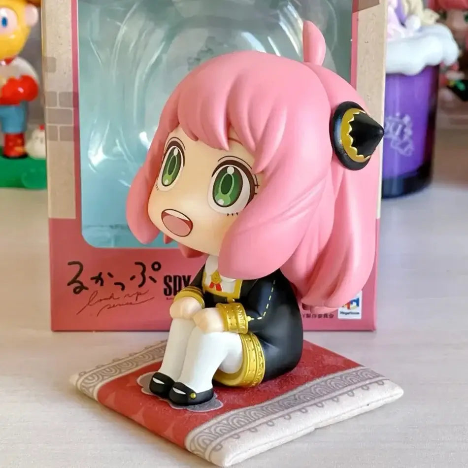Spy x family anya forger pvc figure with pink hair green eyes black and gold outfit seated on patterned mat 14cm model