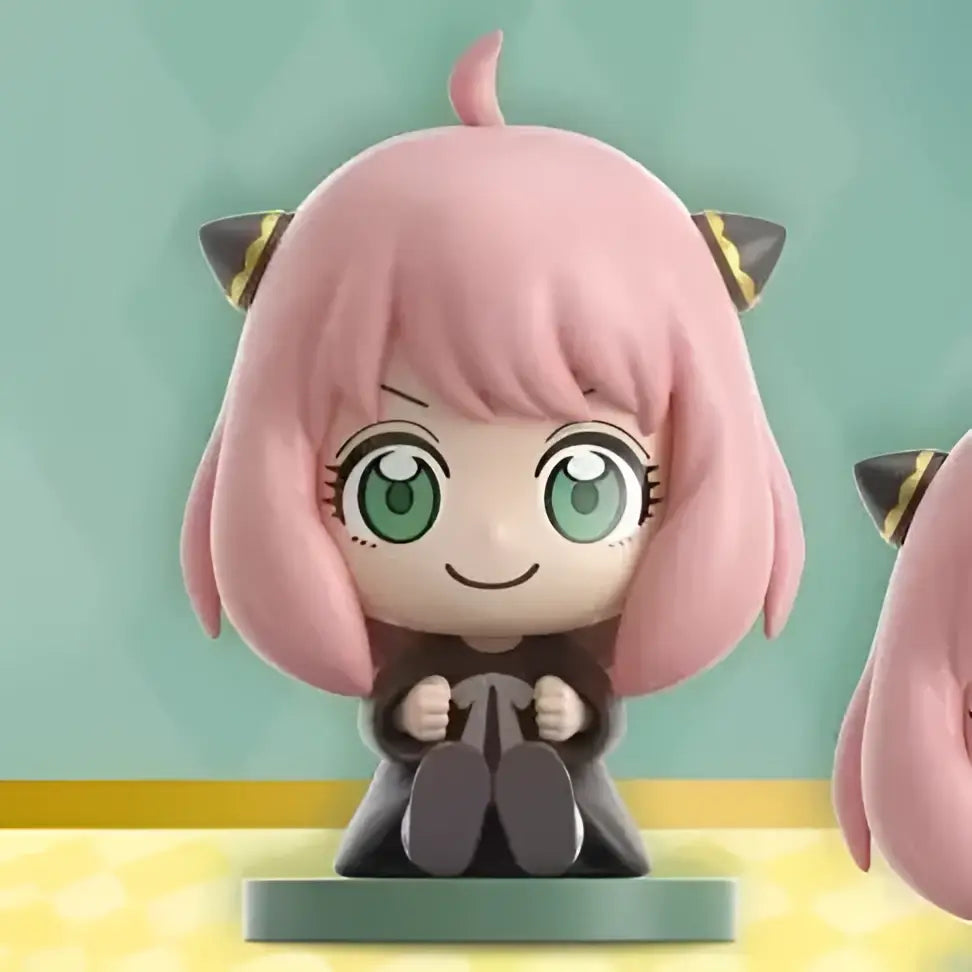 Spy x family anya sitting blind box figure is a pink-haired chibi pvc doll with green eyes and cat ears on teal base