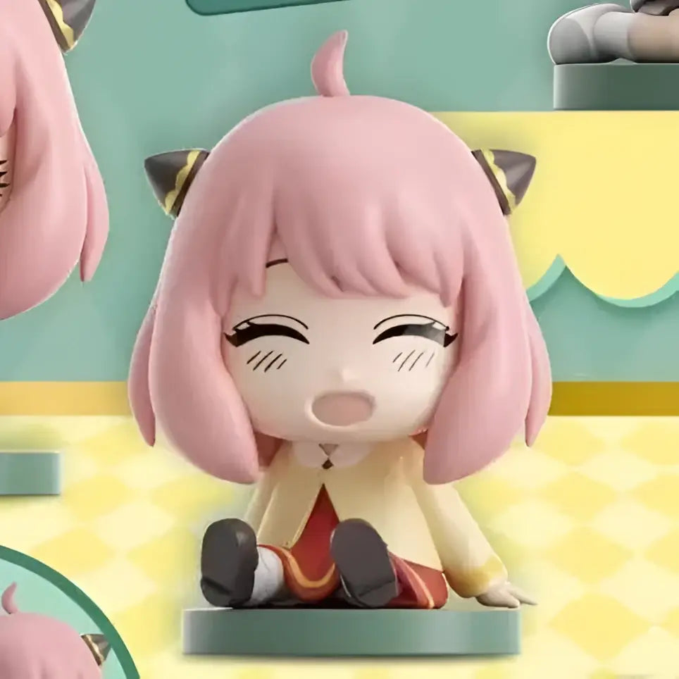 Spy x family anya sitting blind box figure in pvc with pink hair black cat ears yellow top on teal base for desktop use