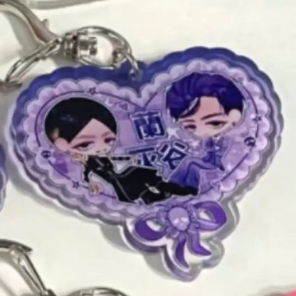 Purple heart-shaped acrylic keychain featuring two chibi tokyo revengers characters with decorative skull bow
