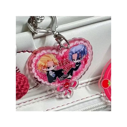 Pink heart-shaped acrylic keychain featuring two tokyo revengers anime characters in black suits with japanese text and ribbon